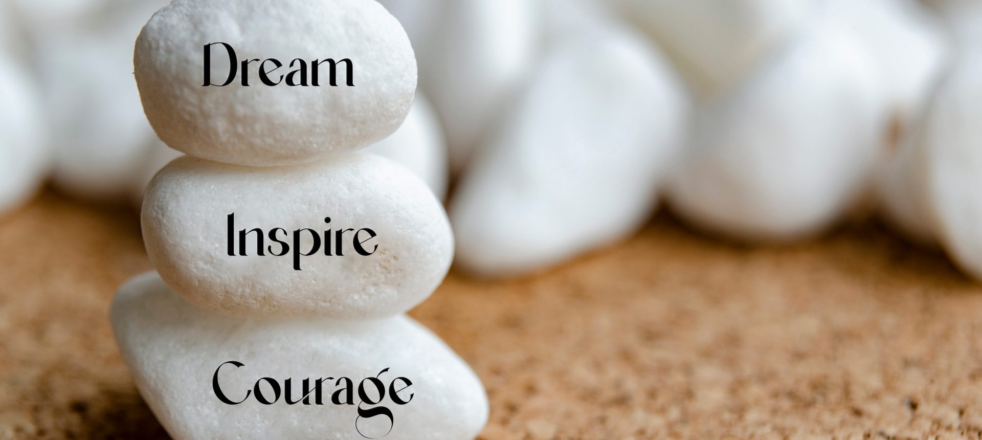 Stacked stones with words: Dream, Inspire, Courage.